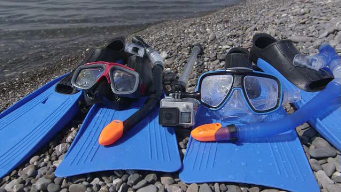 野生卵石滩上的两台浮潜装置和水下数码相机