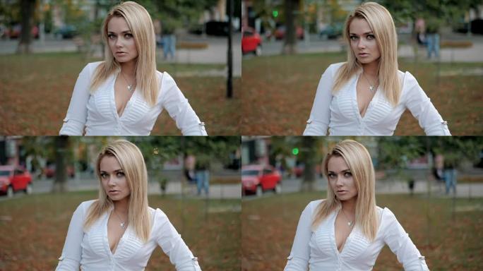城市年轻快乐的金发女商人的肖像。慢动作。街上穿着白色性感衬衫的漂亮女孩