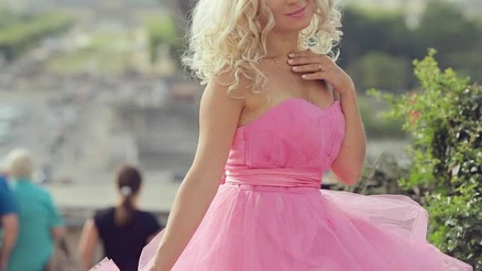 穿着粉红色节日礼服的漂亮女孩坐在埃菲尔铁塔的背景上