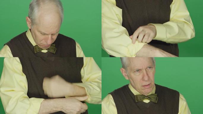 年长的男人在绿屏工作室背景上卷起袖子，表现出不满