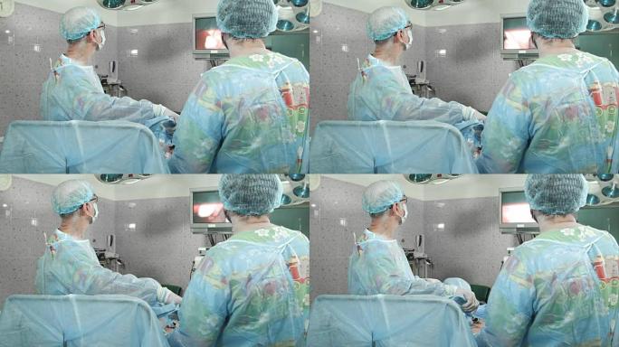 外科医生跟随腹腔镜手术，看着屏幕