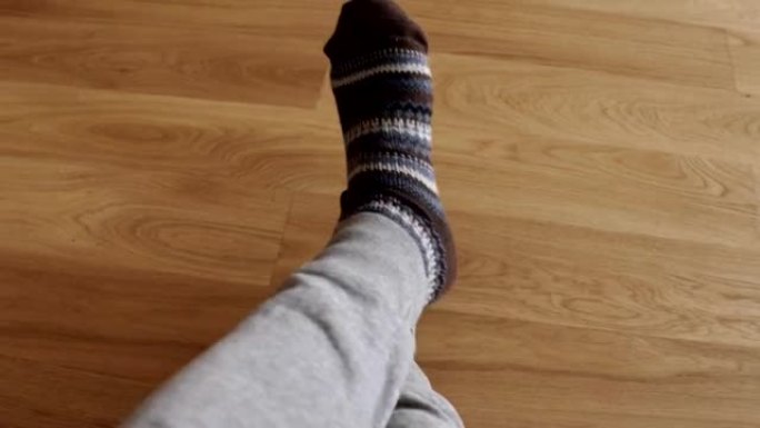 男人的脚穿着保暖的针织袜子。温暖、冬天和舒适的概念。全高清镜头