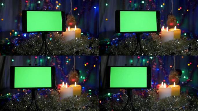 新年的背景，在前景的智能手机与绿屏。一个很好的机会来添加你的问候视频。摄像机的运动。