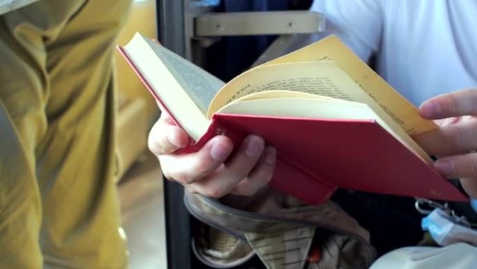 男子在火车上与乘客一起读红皮书。