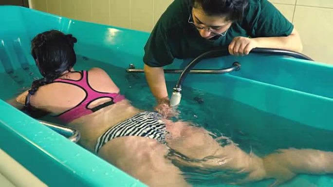 一个穿着泳衣的胖女孩躺在浴缸里，在脂肪团的水力按摩中，慢动作