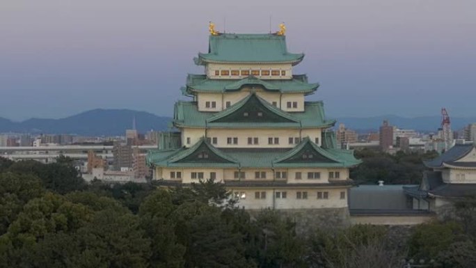 缩小从Nagoyajo城堡到黄昏天空中的城市天际线的镜头。