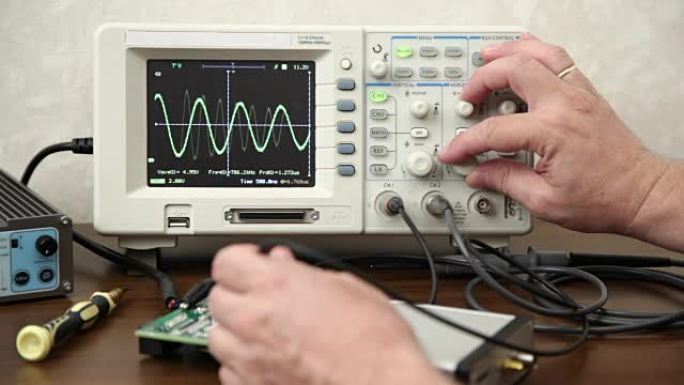 工程师的手在电子设备上测量信号