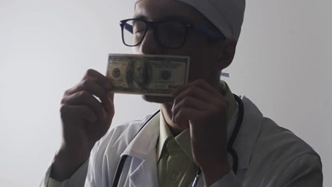 医生亲吻一张100美元的钞票。贿赂医务人员。昂贵的药。