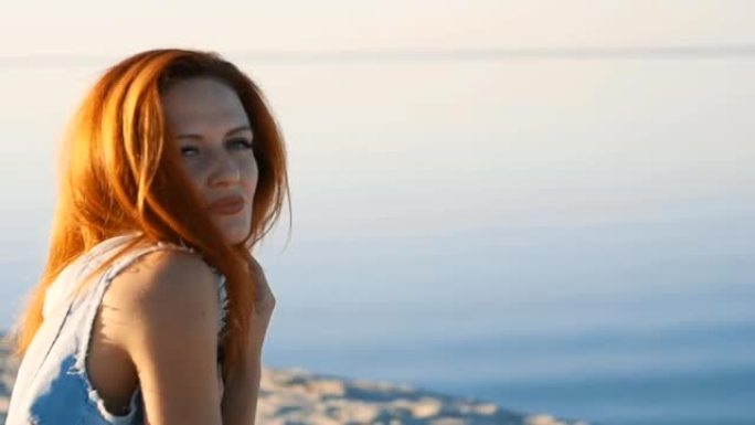 海上背景中一个漂亮的红发女人的肖像