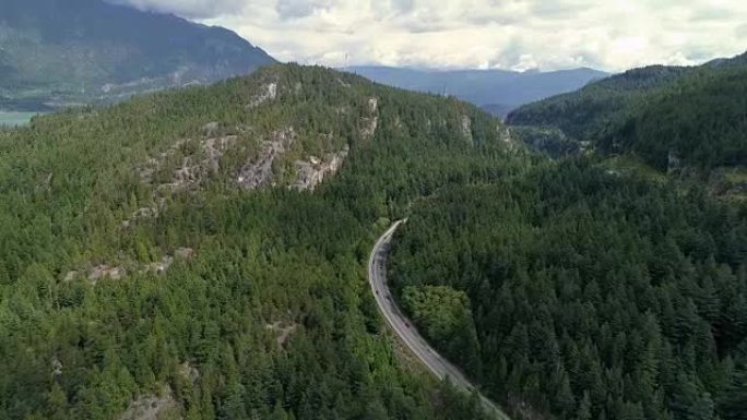 直升飞机的汽车行驶风景秀丽的高速公路进入茂密的绿色森林山脉