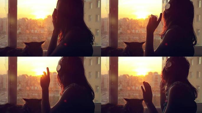 年轻女子戴着耳机，和她可爱的缅因浣熊猫在窗户上放松，日落时城市背景模糊，慢动作