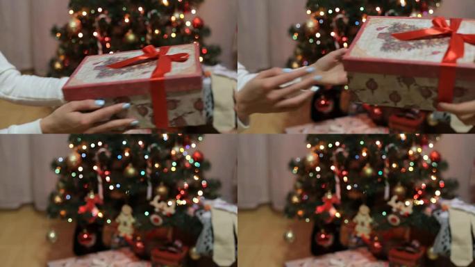 双手在闪闪发光的圣诞树前接受礼物