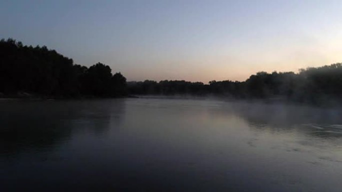 黎明时河流的航拍。旭日背景下从河中升起的薄雾