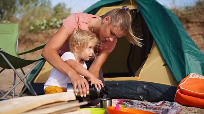 妈妈和女儿想在露营旅行中用热茶取暖