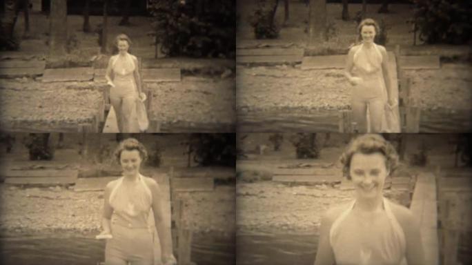 1938: 可爱的女人穿着保守的30年代风格的泳装在湖码头上行走。