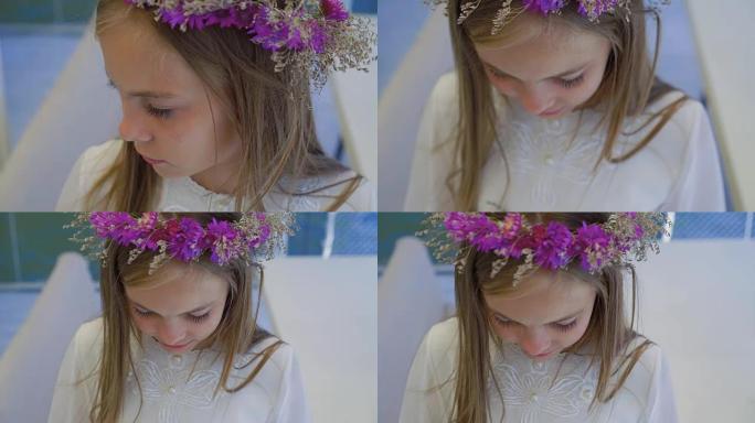 戴着野花皇冠的可爱的小女孩站在全高清摄像机前