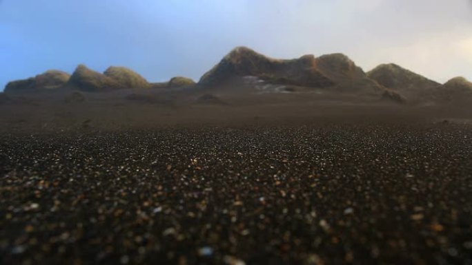 风吹拂的沙子在沙丘的海滩上盘旋，山特维克，冰岛