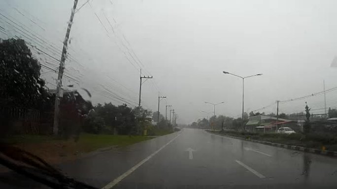 通过带有雨滴的汽车挡风玻璃的道路视图