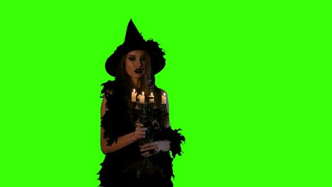 万圣节女巫吹灭绿屏上的蜡烛
