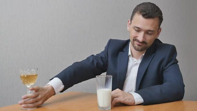 一个男人在一杯酒和牛奶之间进行选择