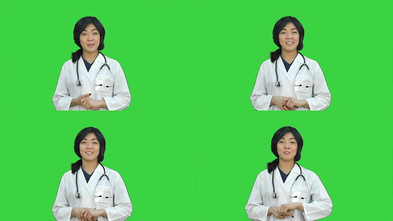 亚洲女医生展示一瓶药片，在绿色屏幕上展示药丸，色度键