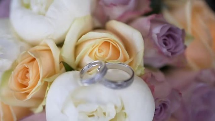 黑色背景上的婚礼花束和戒指