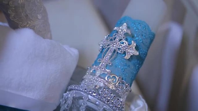 装饰性蓝色蜡烛。带有圣十字的白色大装饰蜡烛。蜡烛上十字架的身影。选择性聚焦