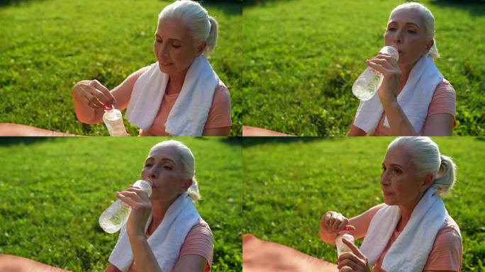 体育活动后快乐的老年妇女喝水