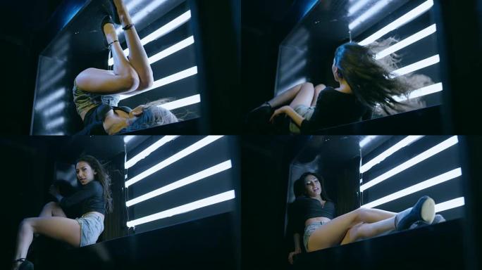 性感的黑发女孩跳舞，躺在立方体上。在慢动作的红色史诗巨龙电影相机上拍摄。