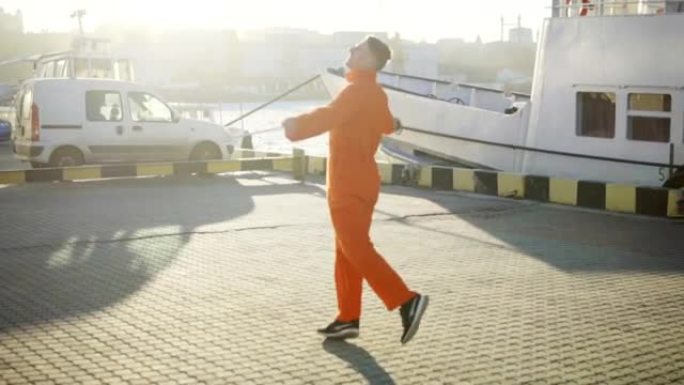 穿着橙色制服的年轻港口工人正在阳光下转转。快乐的年轻人正在庆祝一些事情。