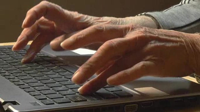 一个老太太在笔记本电脑键盘上打字的手