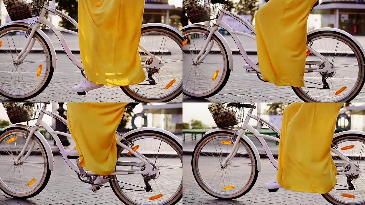 白色城市自行车车轮旋转的特写视图。带铃铛、篮子和鲜花的城市自行车。一早骑城市自行车的面目全非的女人。