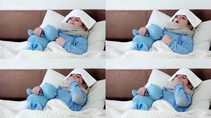 生病的样子，嗓子疼的小男孩，婴儿测量温度电子温度计，孩子脖子上围着围巾躺在床上
