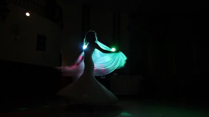 新娘在彩色灯光下在黑暗中旋转
