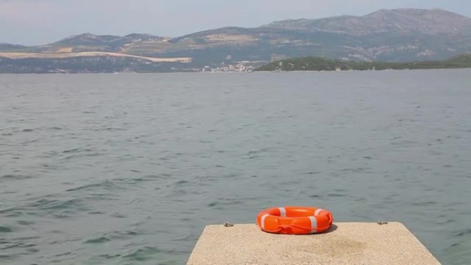 一个红色的救援浮标躺在一个小码头上