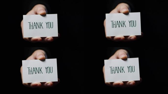 一只手展示一张卡片，上面写着: “谢谢”。商业概念，谢谢，记录网站。