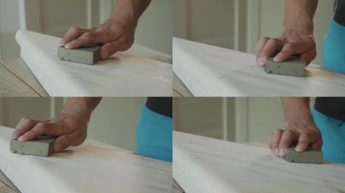 用砂纸打磨木步的男性双手特写