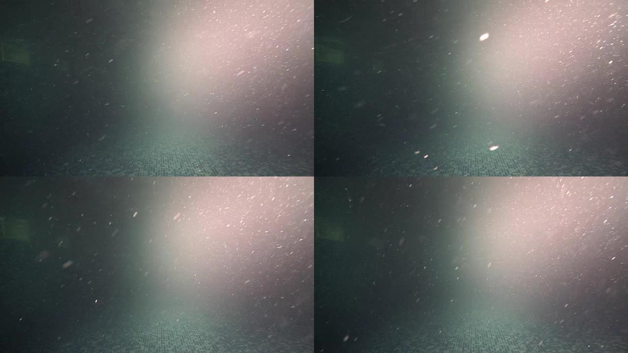 黑暗的水池脏水，周围漂浮有颗粒，水下视图背景