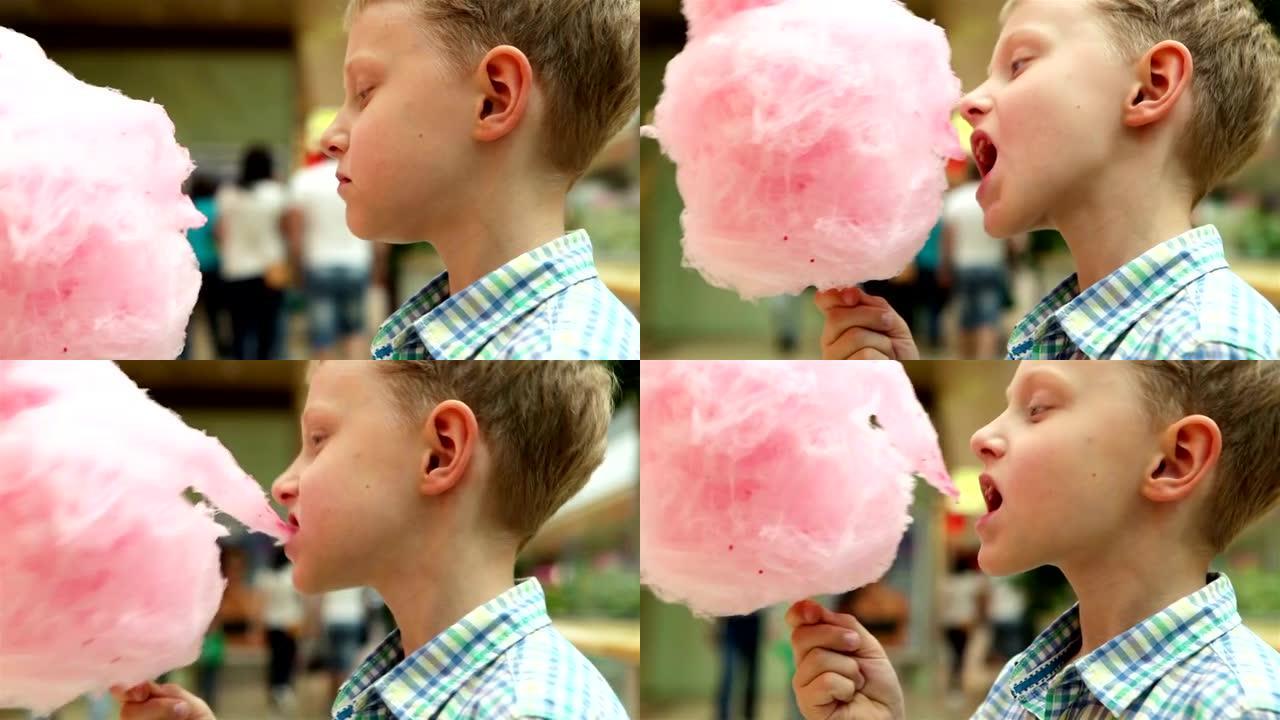 一个小男孩用食欲不振的粉红色糖果牙线的慢动作镜头