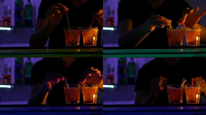 调酒师正在制作鸡尾酒，在吧台倒酒，在黑暗中与小管混合，射击，慢动作