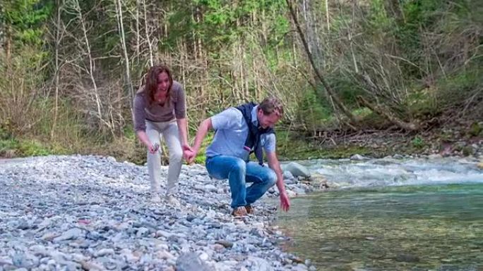 这对恋爱中的中年夫妇来到小溪，然后他们就在小溪的水边，他们正流经美丽的风景。