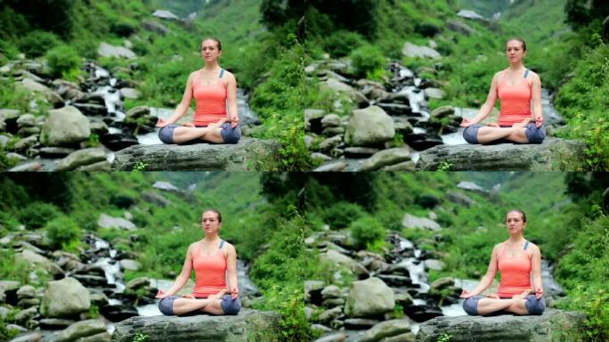 女人在莲花的热带瀑布上冥想姿势Padmasana