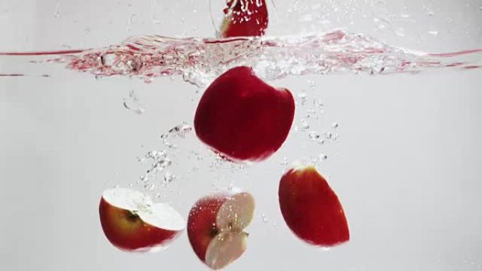 苹果在白色背景上掉入水中