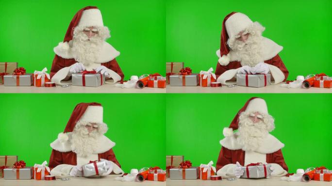 圣诞老人正在用银色纸包装礼物