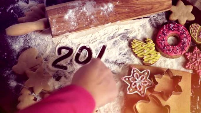 圣诞烘焙背景。女孩在桌子上写字2017