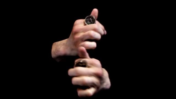 魔术师在黑色背景上展示硬币技巧