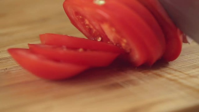 用银刀在木盘上切番茄。