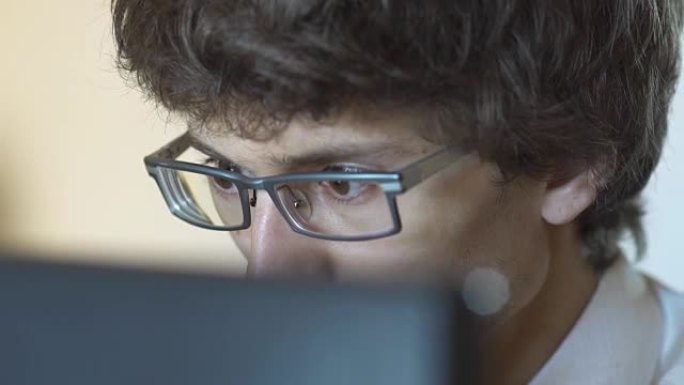无法识别的人在户外桌子上使用现代便携式计算机，背景是街道