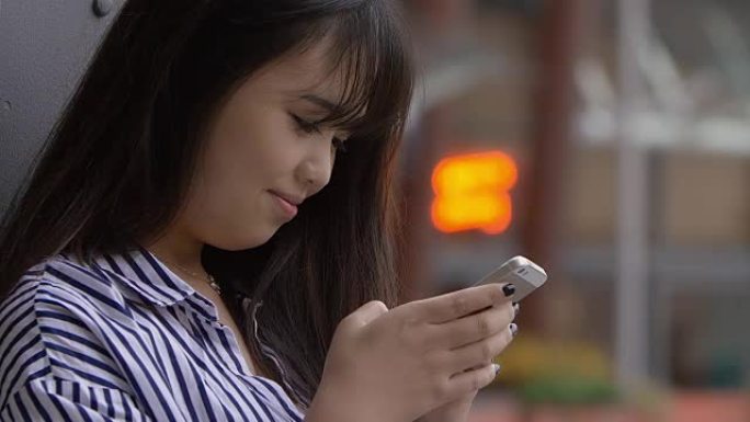 年轻的中国妇女用手机在facebook上聊天: 发短信