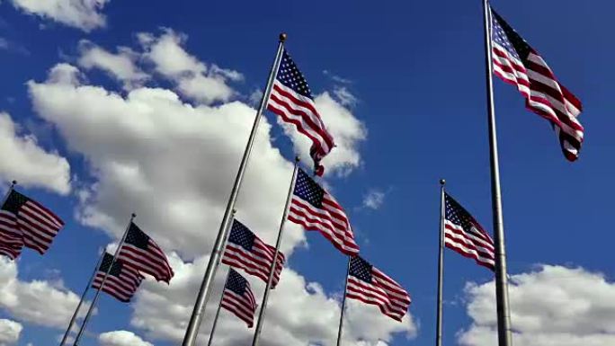 在晴朗的日子里，那一大群飘扬的美国国旗映衬着蓝天和灿烂的云朵。